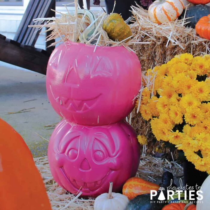 Pumpkin candy baskets painted pink and filled with hay and gourds for display