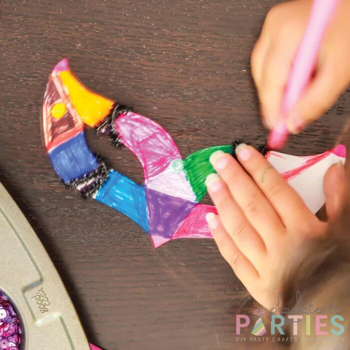 close up of a mask template being colored by a child