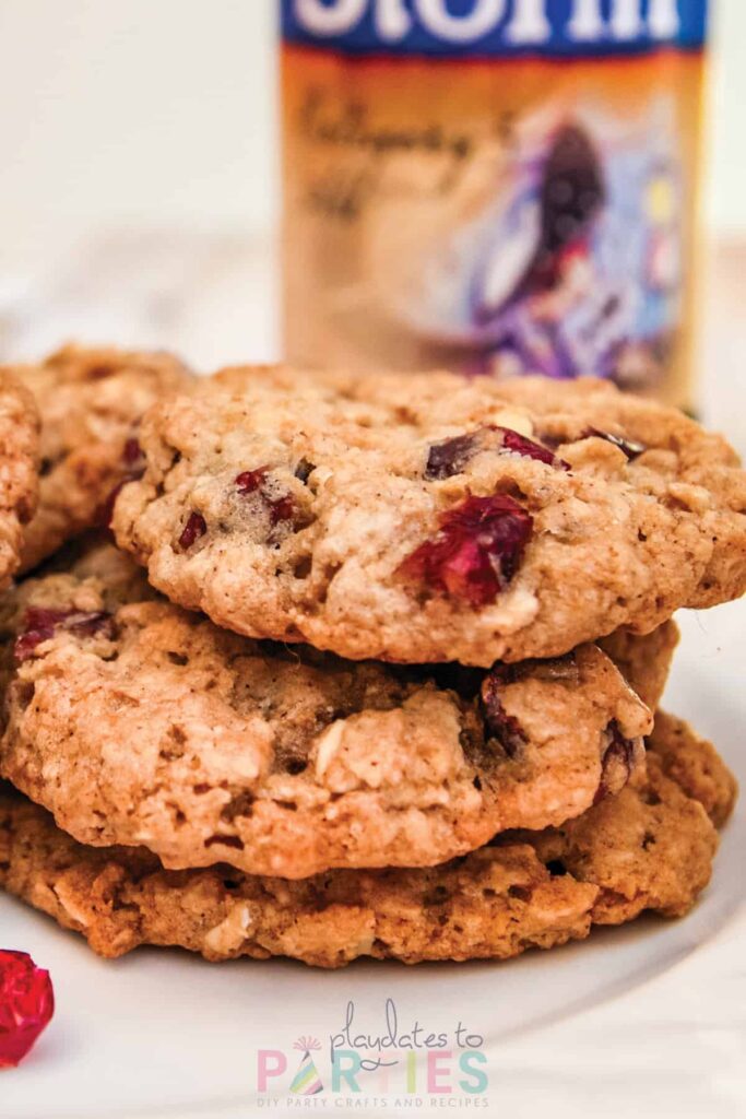 a stack of cranberry oatmeal cookies in front of a bottle of beer