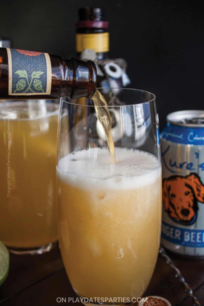 close up of beer being poured into a tall glass with a dark background