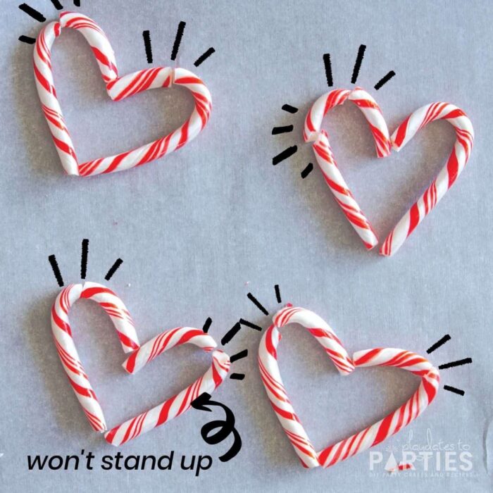 candy canes on parchment paper arranged to create hearts. But the candy canes are broken and don't all sit properly