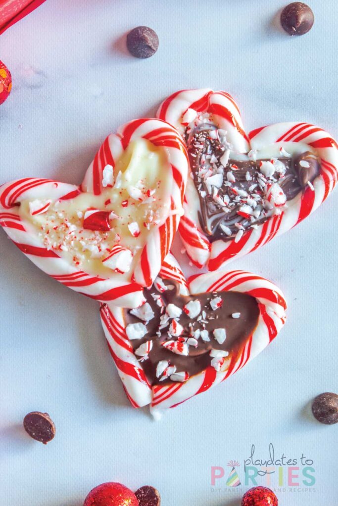 finished candy cane hearts on a white surface. one with all white chocolate, one with all semi sweet chocolate, and one with swirled chocolate centers