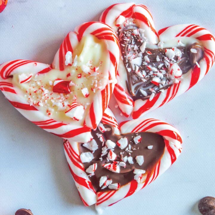 three candy cane hearts filled with chocolate on a marble table