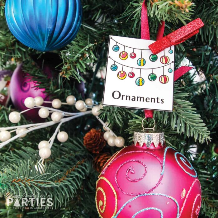 close up of a Christmas tree with a card attached that says ornaments