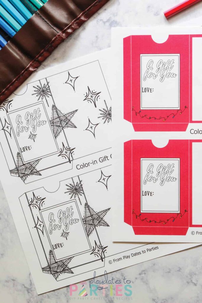 two pages of DIY gift card templates printed out, but not yet cut. One is all black and white with star shapes. One is red with a white window