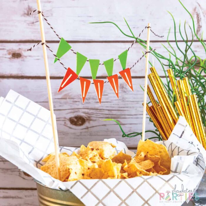 close up of chips in a bucket with mini printable bunting that looks like football laces