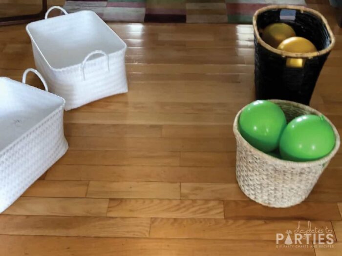 four baskets set up on the floor. two are filled with balloons and two are ready to fill