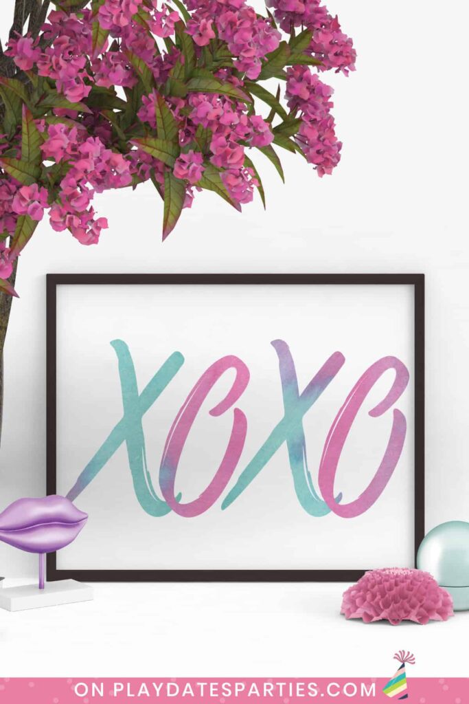 framed landscape print with a black frame. The print has large letters XOXO in watercolor script