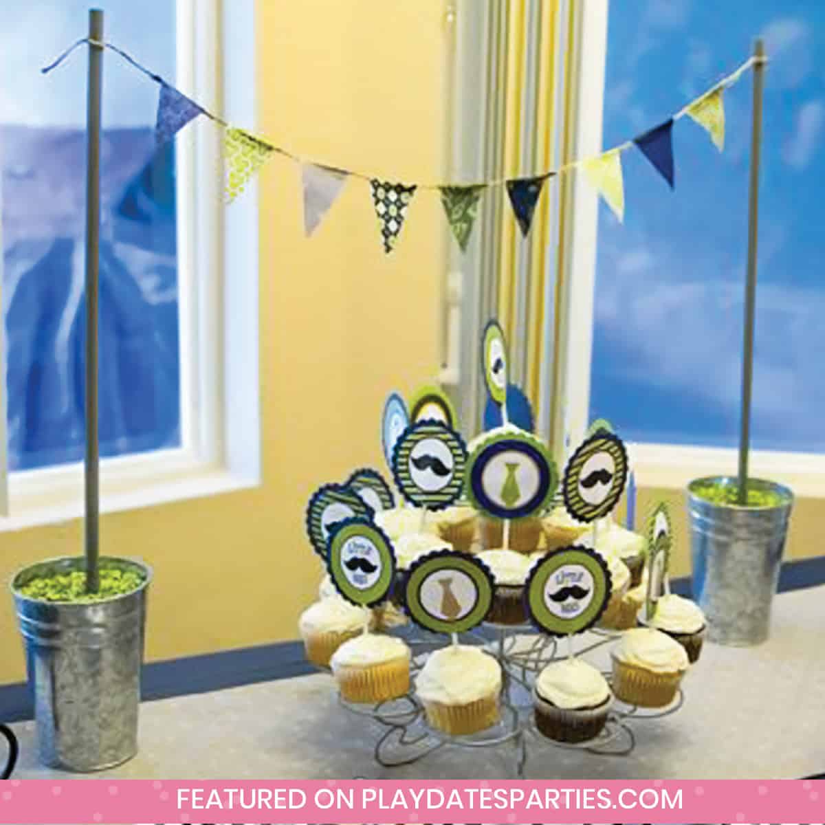 cupcakes on a table with a mini bunting strung over top