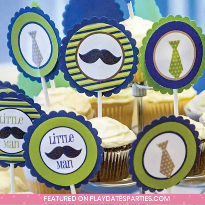 close up of green and blue party cupcake toppers with mustaches and neckties that say little man