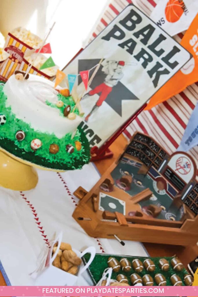 angled photo of a party table with a cake, wooden baseball themed game board, and snacks