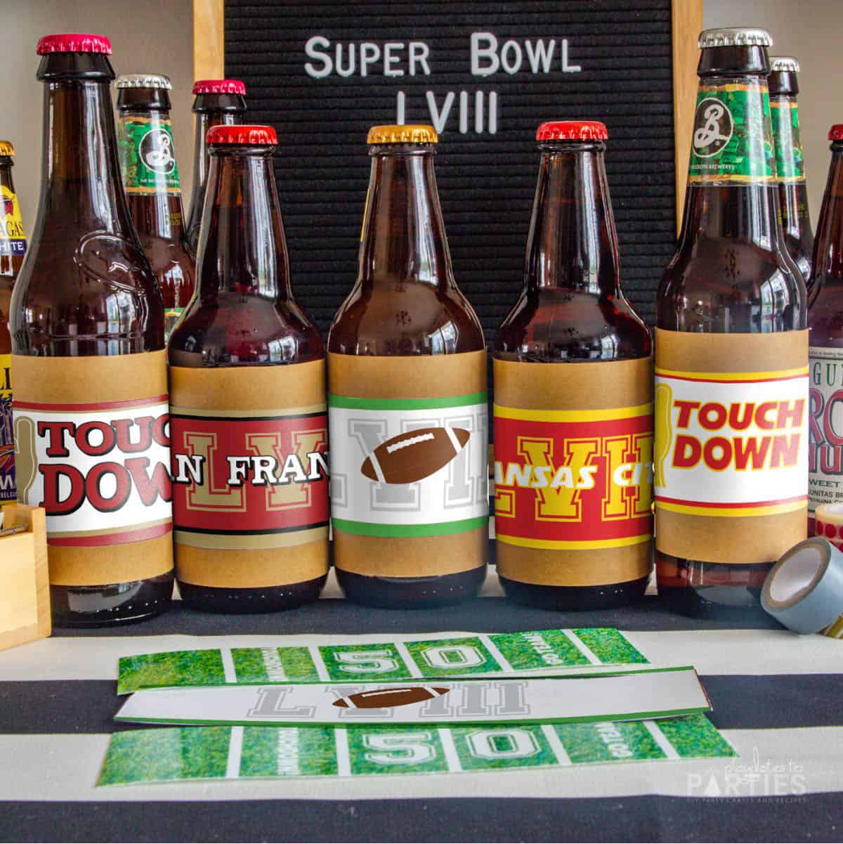 five beer bottles in a row on a table wrapped with football labels