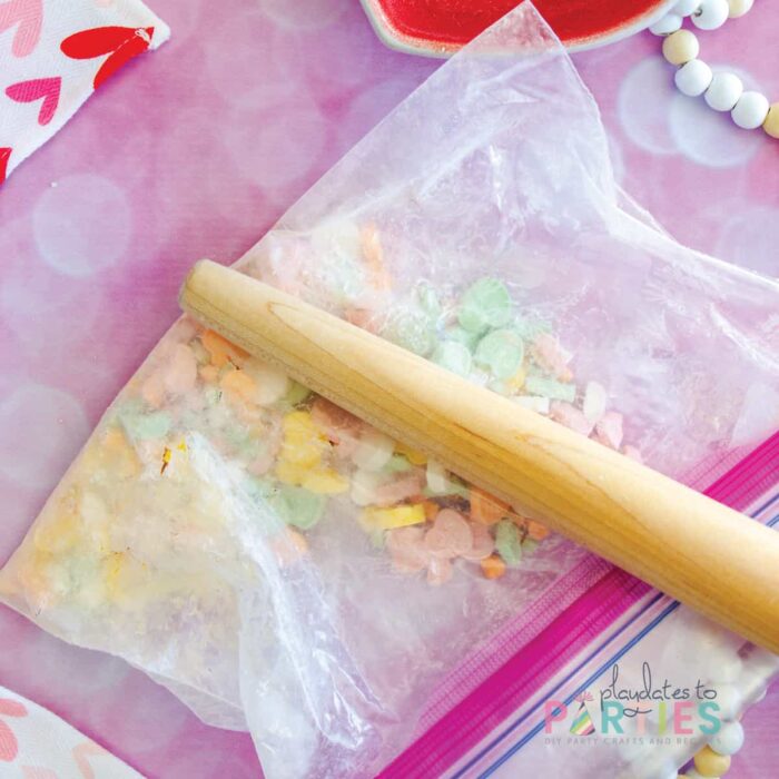 crushing conversation hearts in a zip top bag with a rolling pin