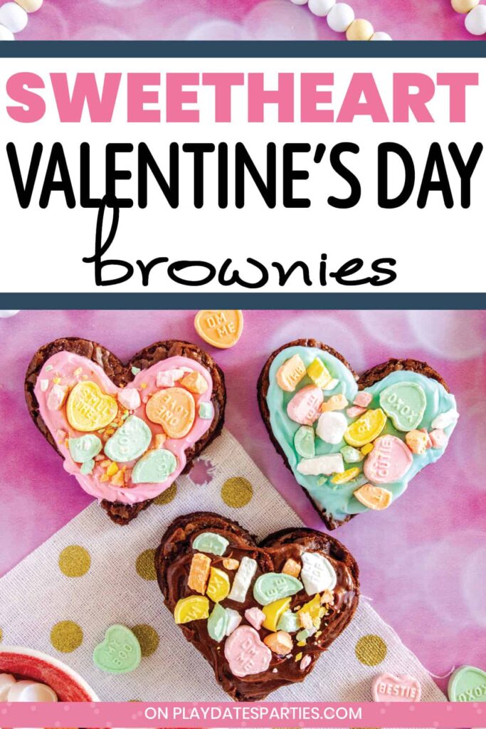 three heart shaped brownies on a pink surface surrounded by conversation hearts with the text Sweetheart Valentine's Day brownies