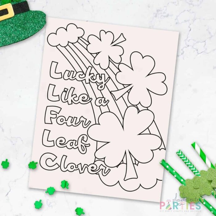 coloring sheet with a rainbow and four leaf clovers that says Lucky like a four leaf clover on a marble table with green decorations around it.