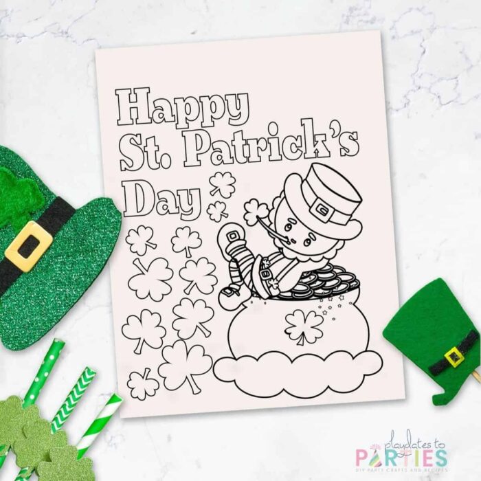 coloring sheet with a leprechaun that says Happy St. Patrick's Day on a marble table with St. Patrick's day decorations around it.