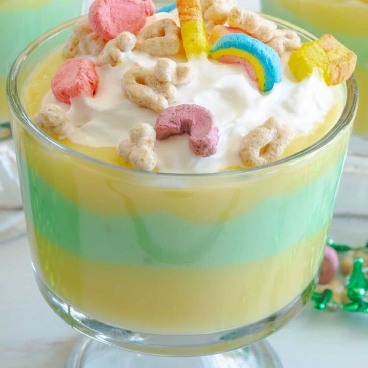 close up of a St. Patrick's Day pudding parfait with green and yellow pudding and Lucky Charms cereal on top