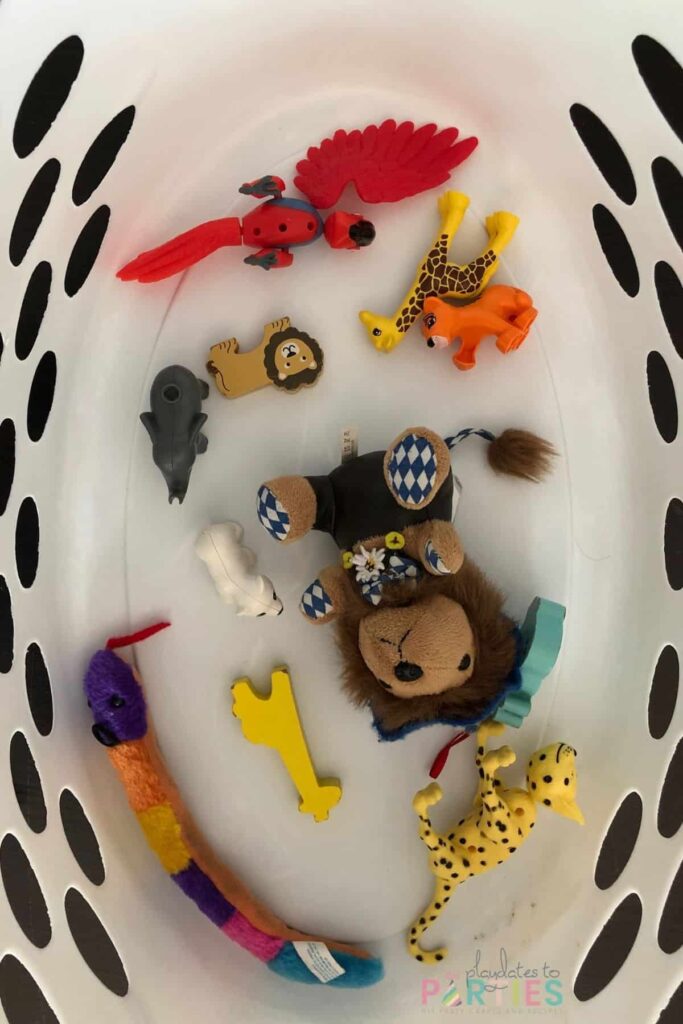 overhead view of laundry basket with toy animals on the bottom