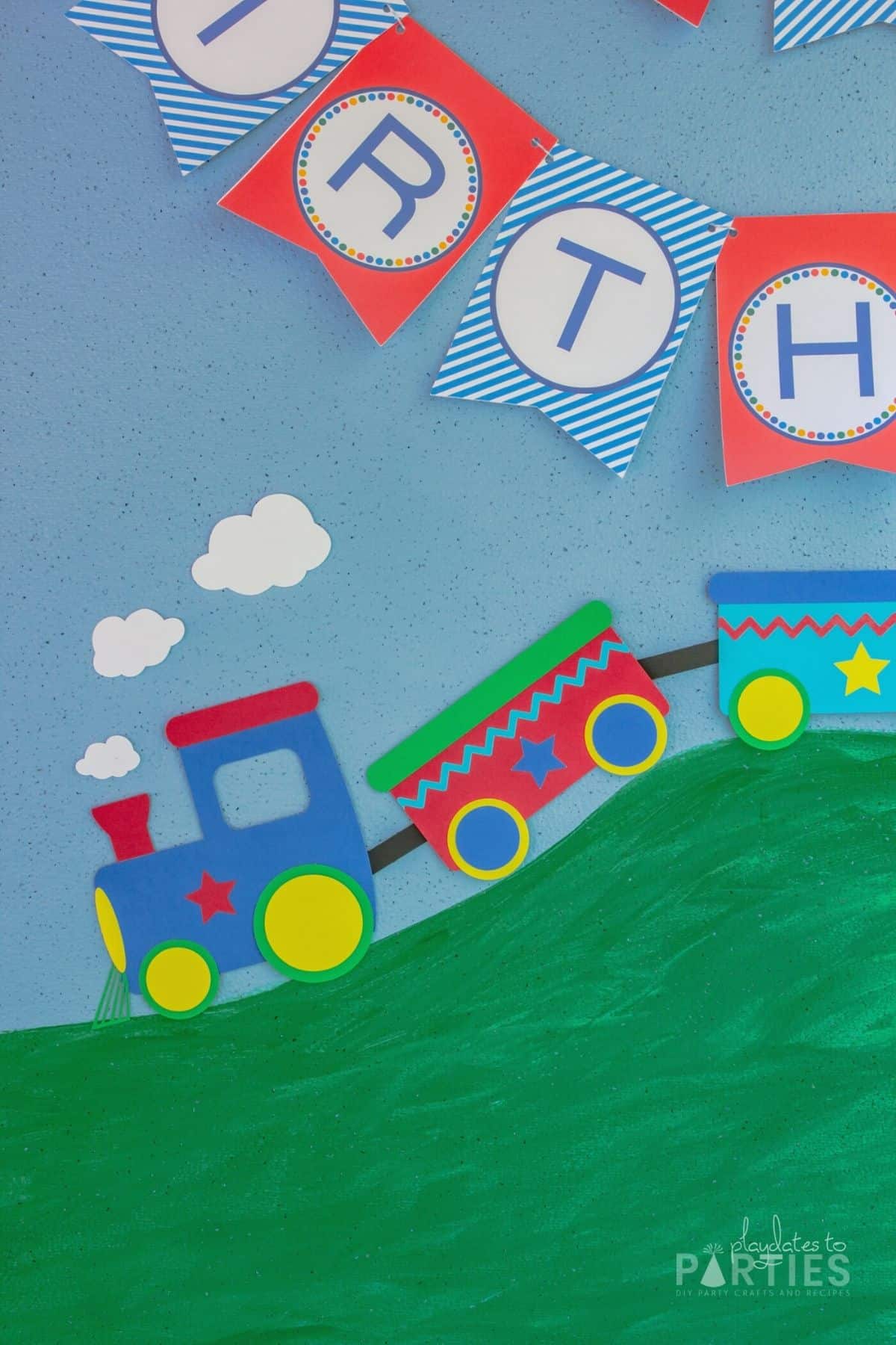 close up of 2 dimensional paper train on a blue backdrop that looks like it's rolling down a hill