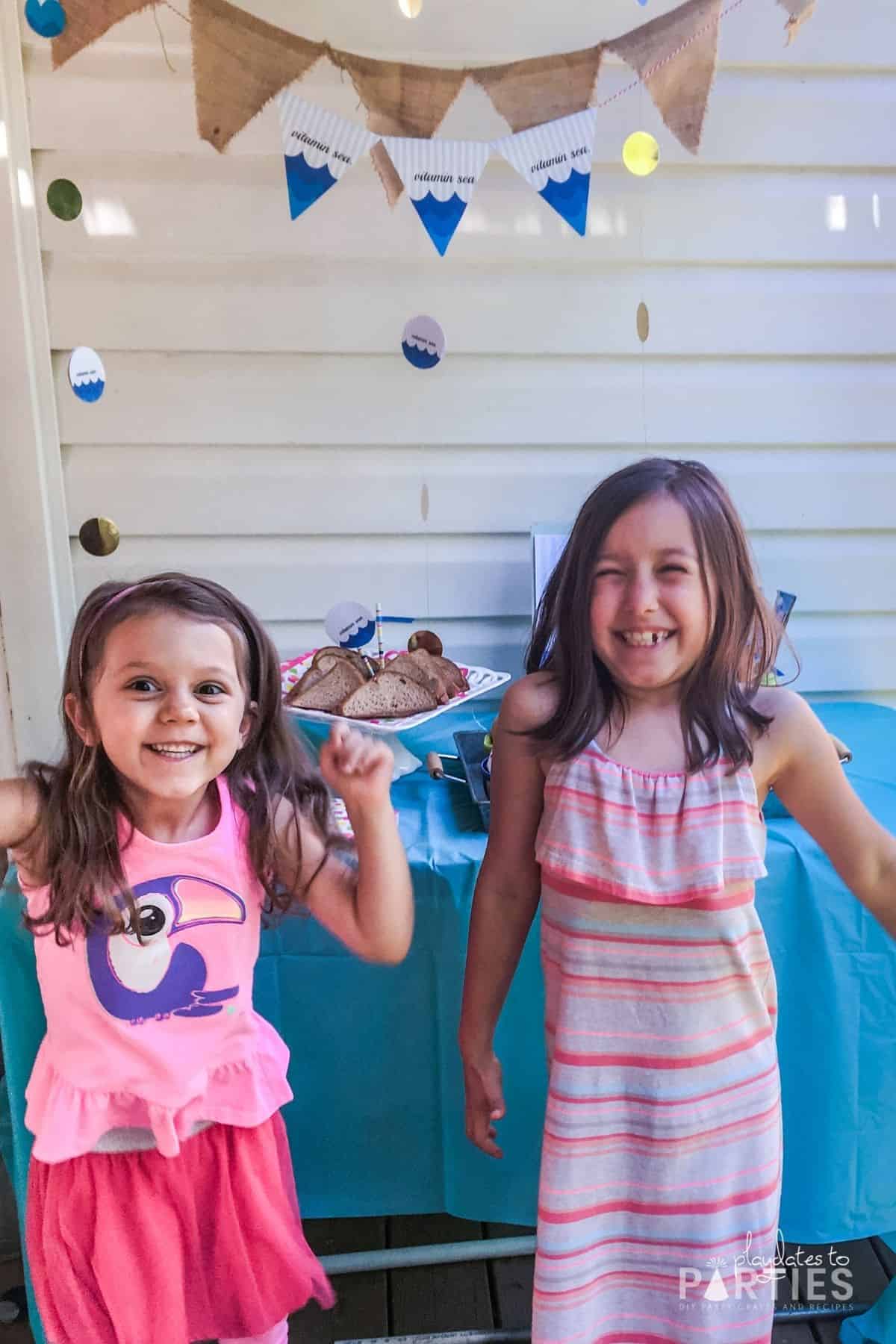 two girls in front of a party table cheering the last day of school