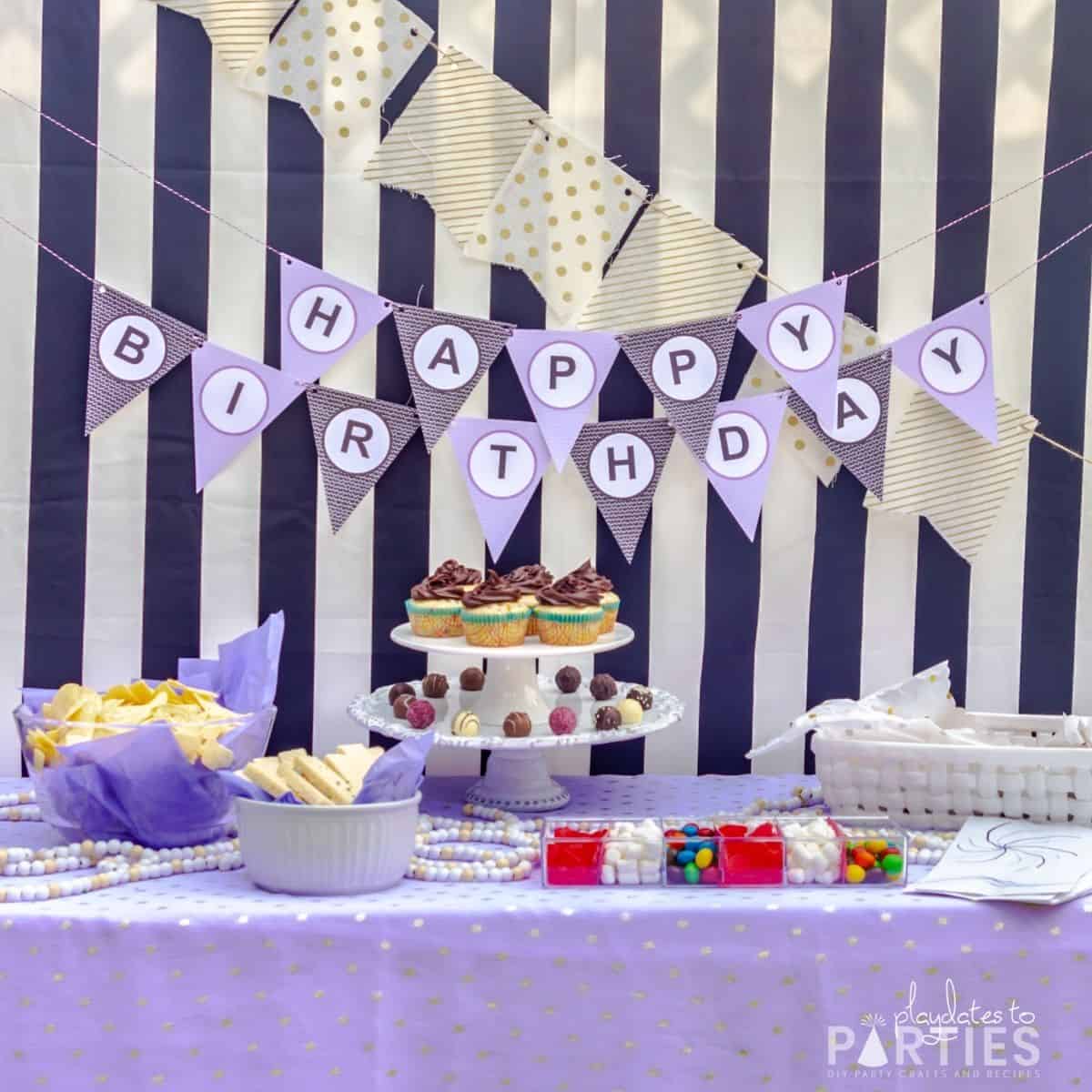 straight ahead view of a snacks table with a simple paper banner, and easy store bought movie snacks