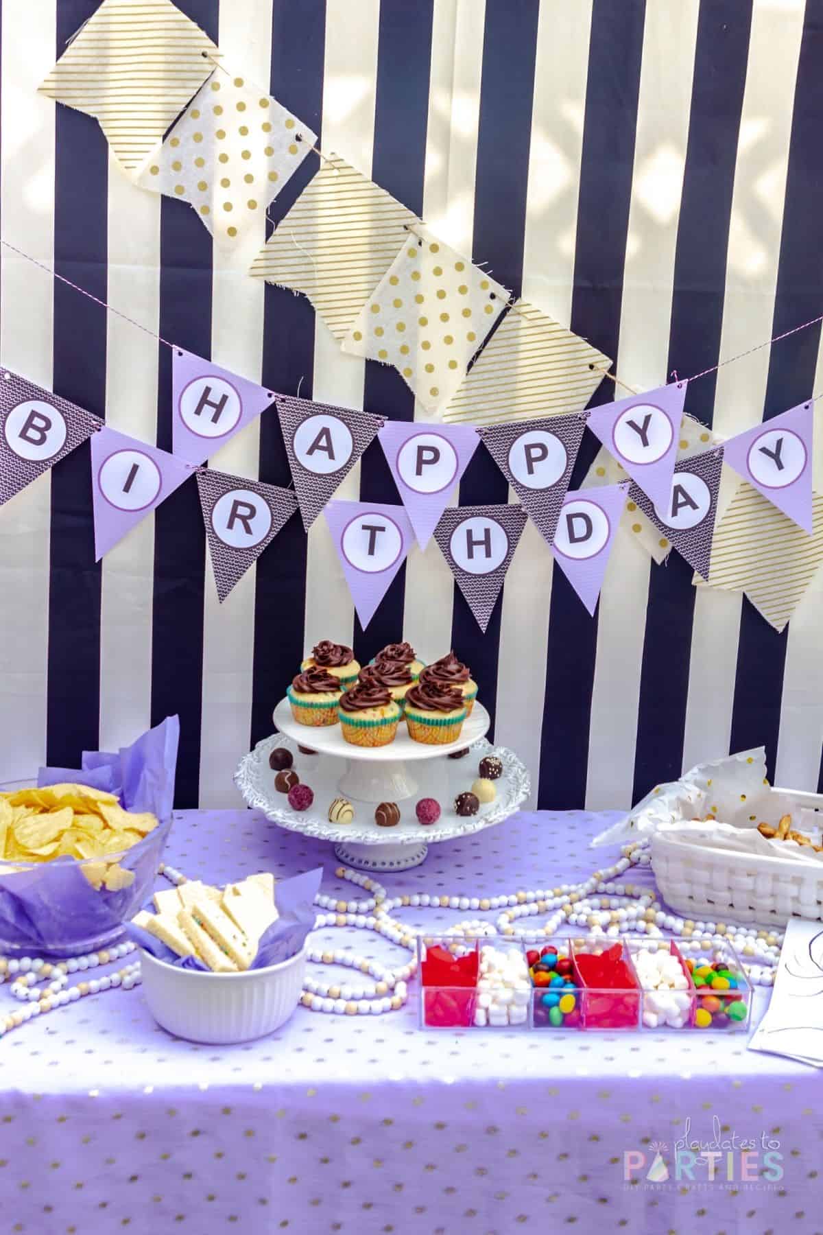 simple dessert table setup with easy store-bought movie snacks for treats on a purple and black themed color scheme, with gold accents