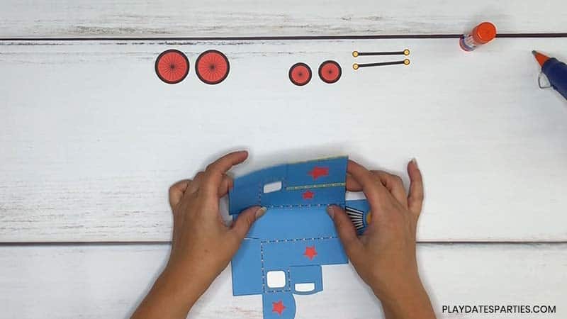overhead image of a woman's hands folding the cut train template