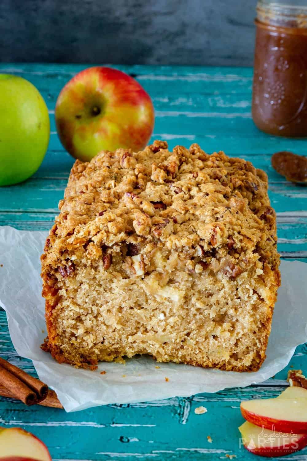 A look at the inside of a loaf of quick bread with visible apple chunks and streusel topping.