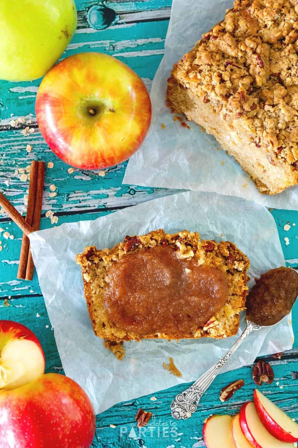 A slice of quick bread with a smear of apple butter on a piece of parchment paper.