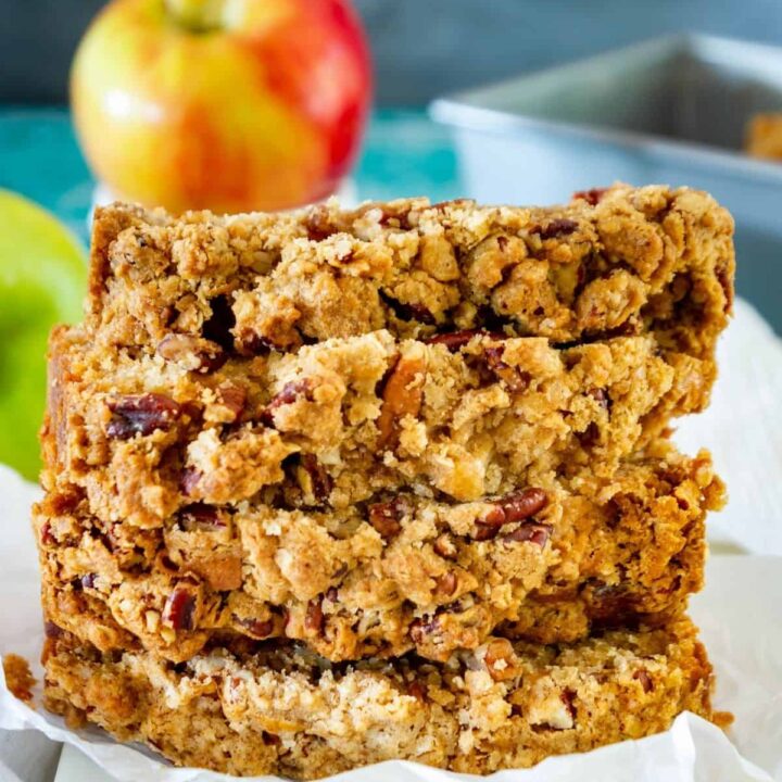 A stack of apple bread slices on a marble board showing the pecan streusel topping.