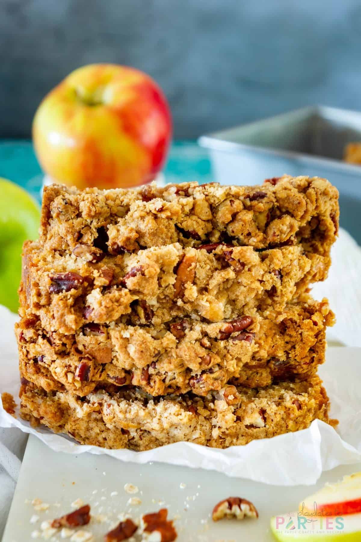 A stack of apple bread slices on a marble board showing the pecan streusel topping.