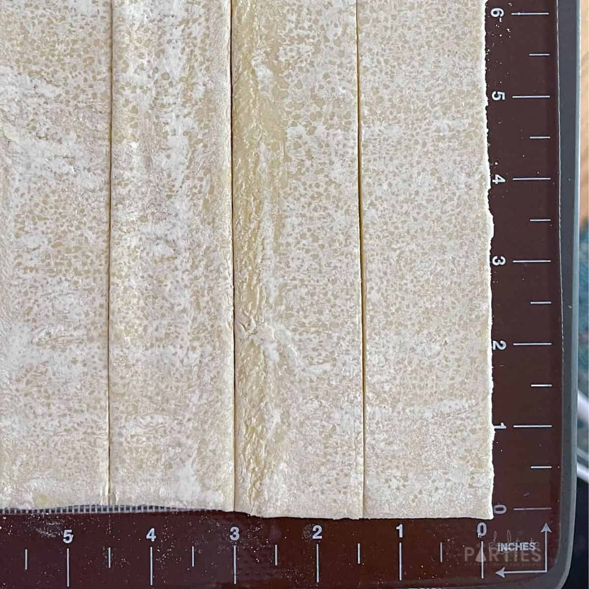 puff pastry on a baking mat cut at 1.5 inch increments