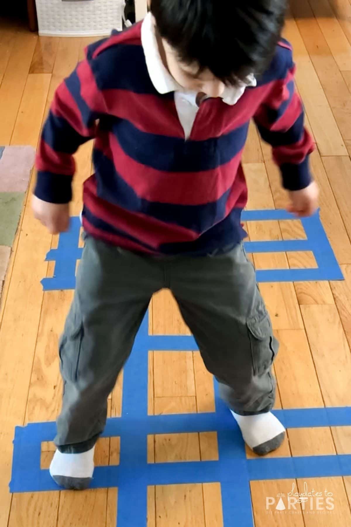 photo of a young boy finishing an indoor hopscotch course