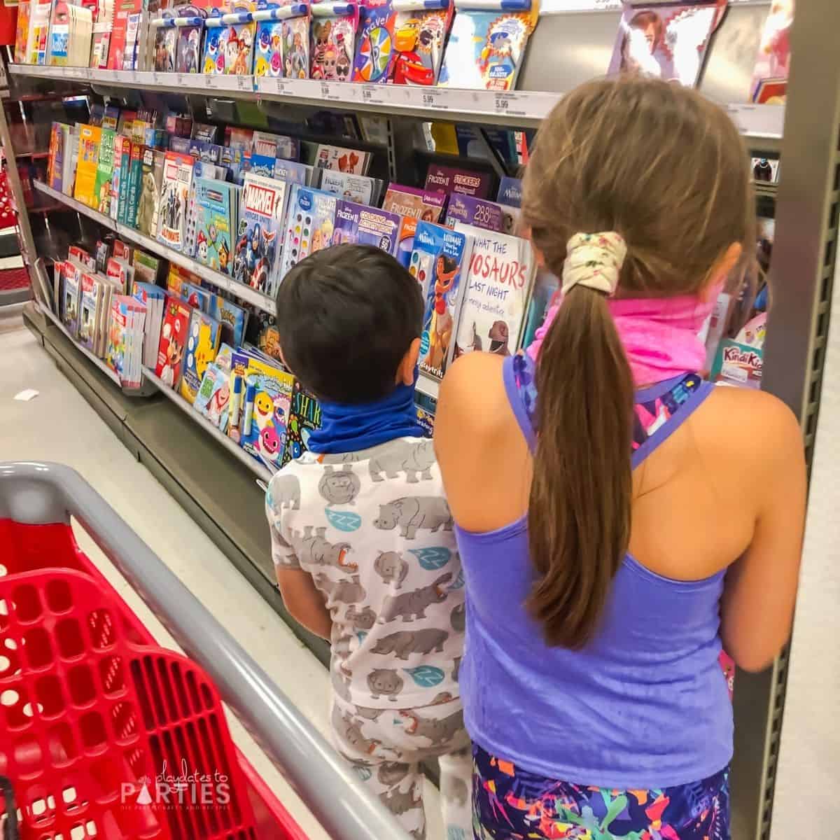 image of a boy in pajamas and an older girl shopping in the Target book aisle.