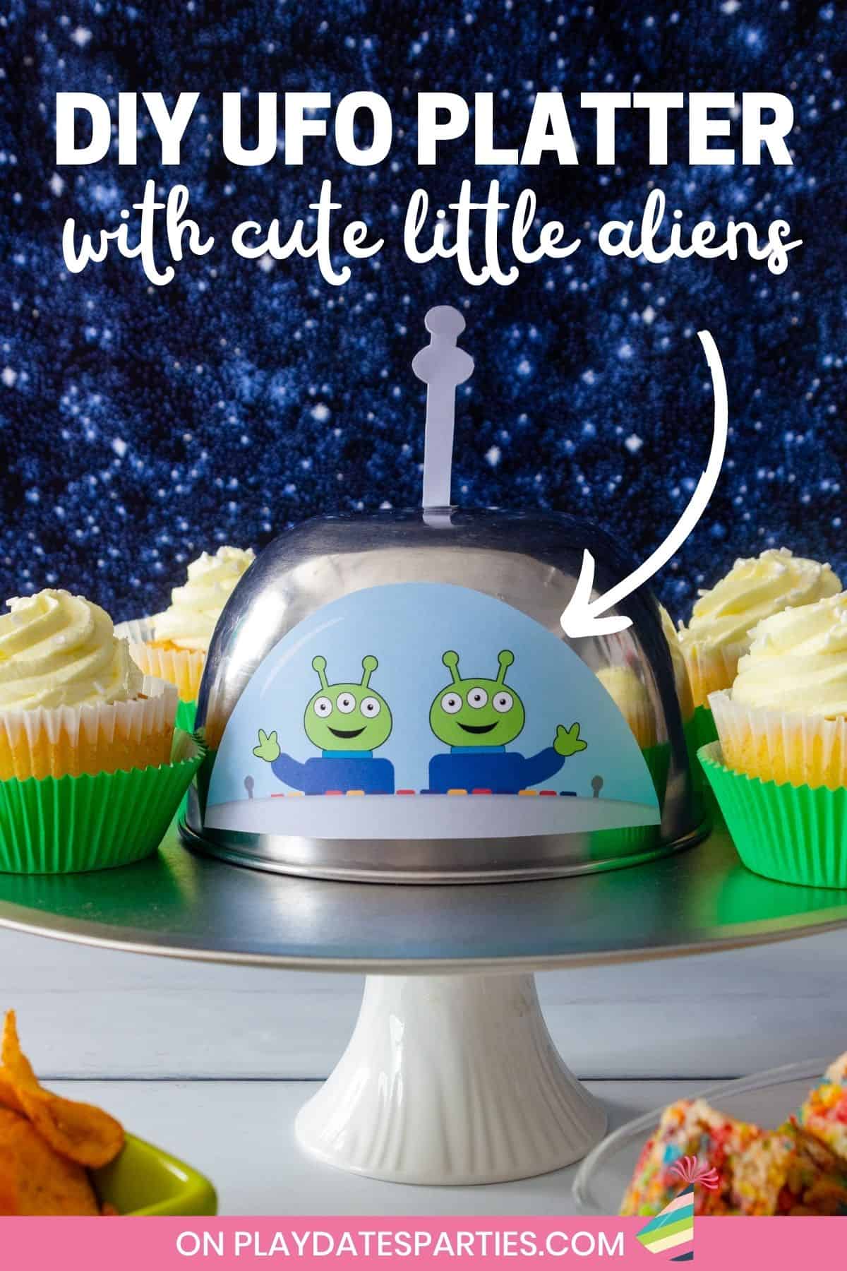 Front view of a party platter decorated to look like a UFO with cute aliens looking out a window.
