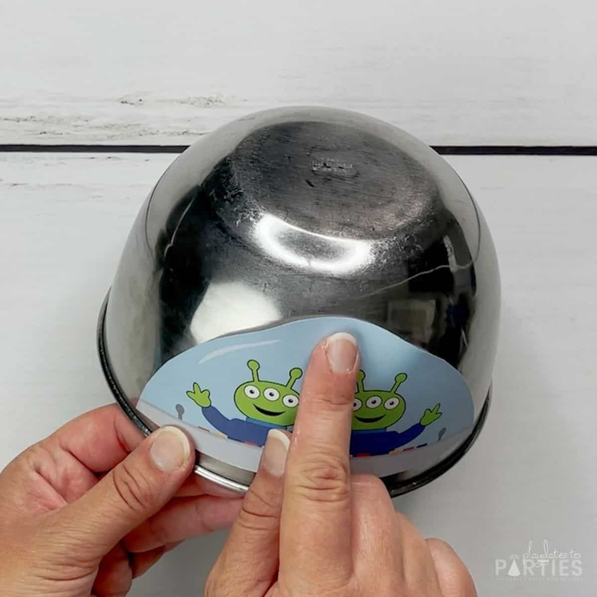 A woman's hand demonstrating how the top of the alien window won't lie flat on the mixing bowl.