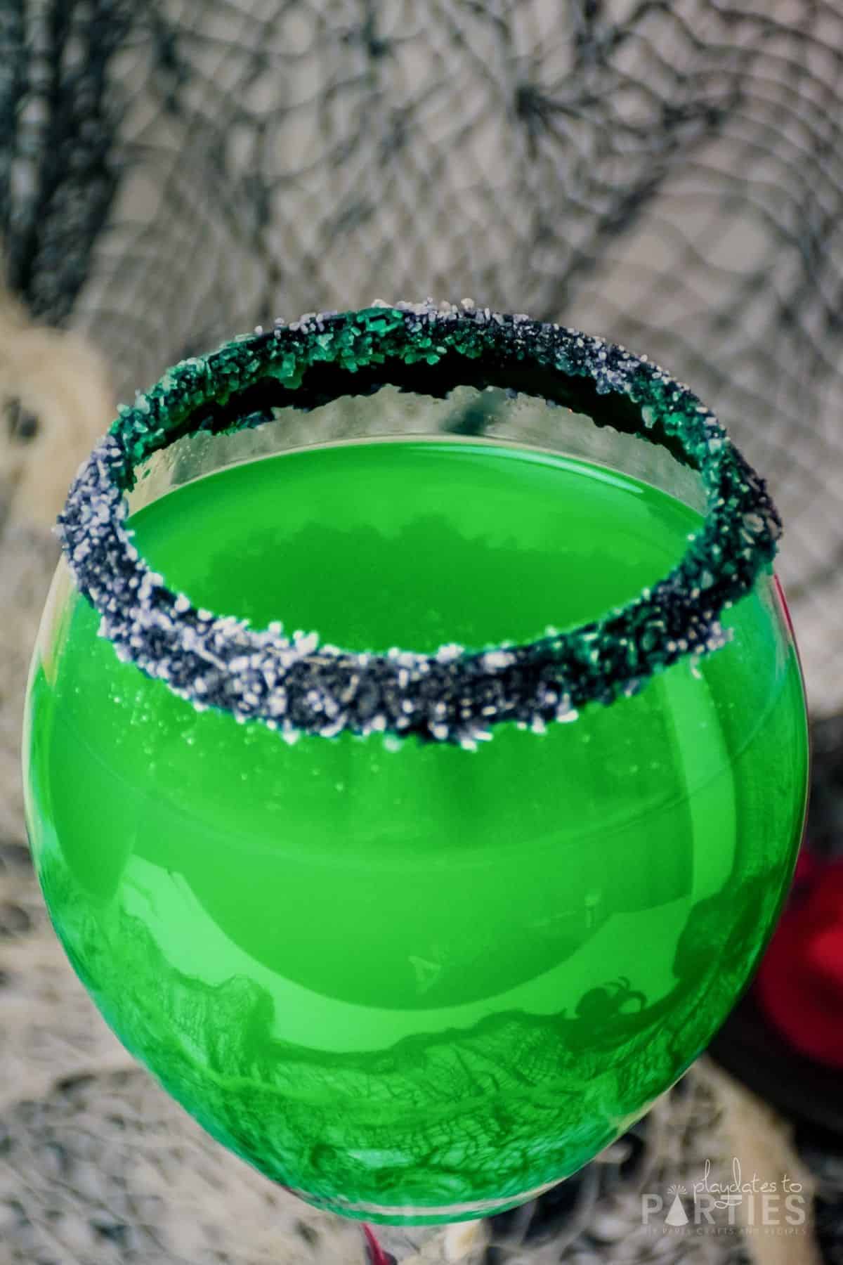 Green Halloween cocktail rimmed with black and white salt.