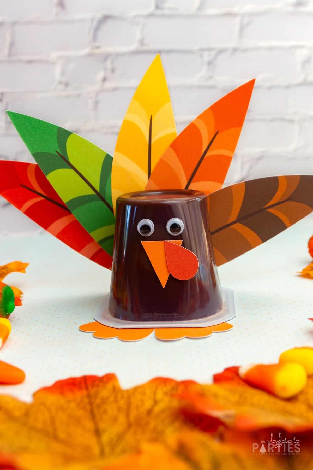 A completed turkey pudding cup in front of a white brick wall.