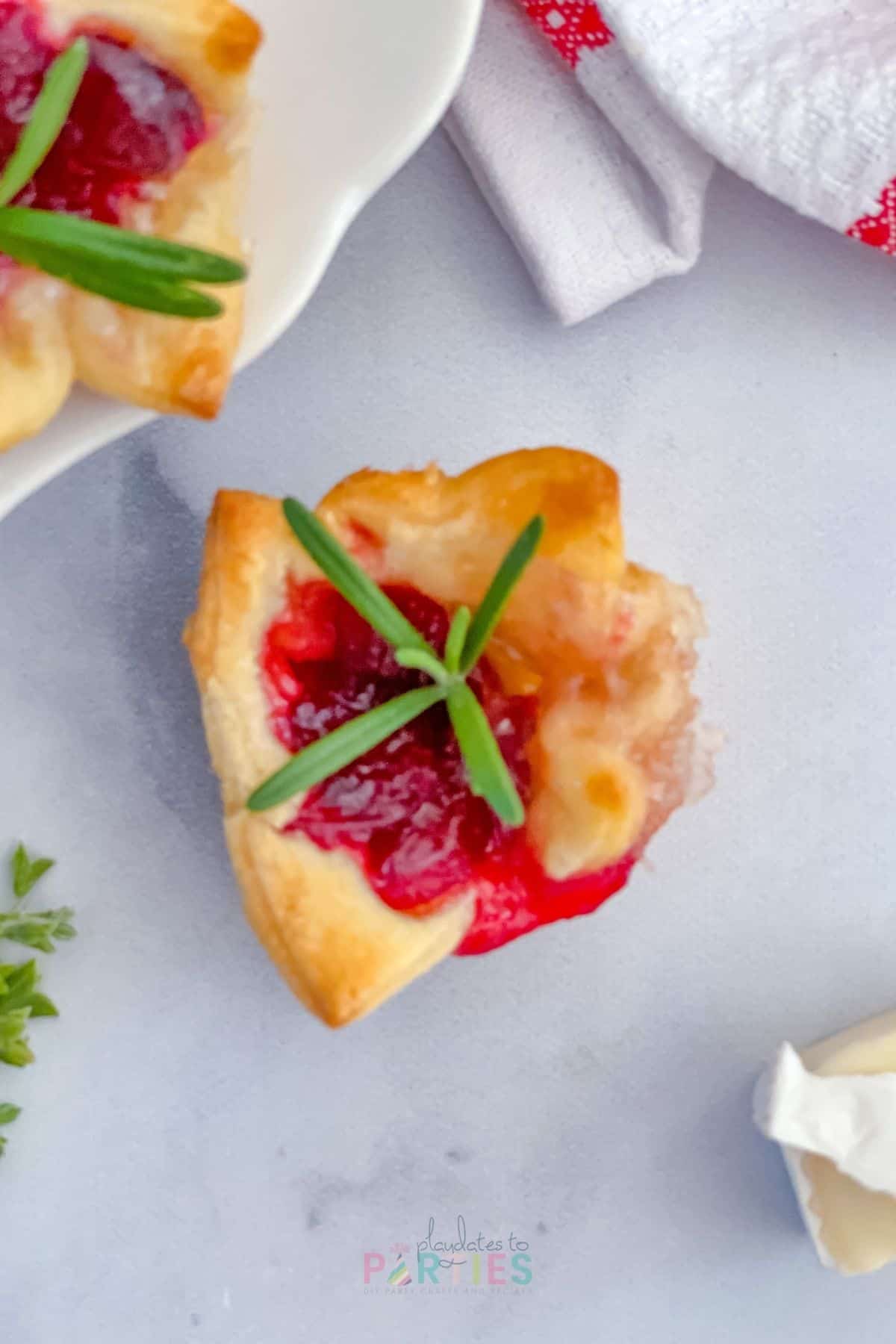 Overhead view of a fall appetizer made with leftover cranberry sauce and soft cheese on a marble surface.