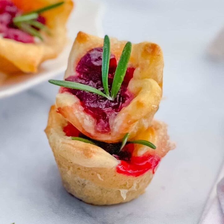 Closeup view of two appetizers stacked on a marble surface.