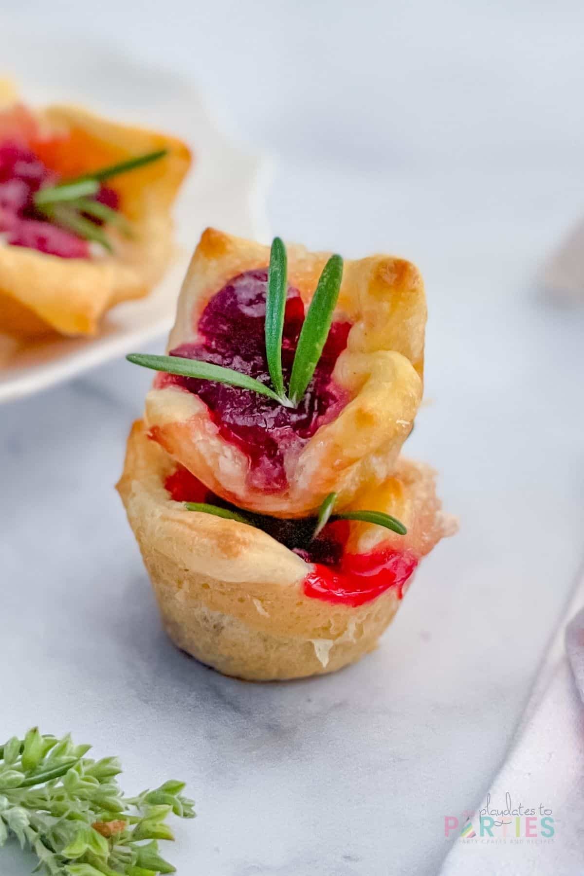 Closeup view of two appetizers stacked on a marble surface.