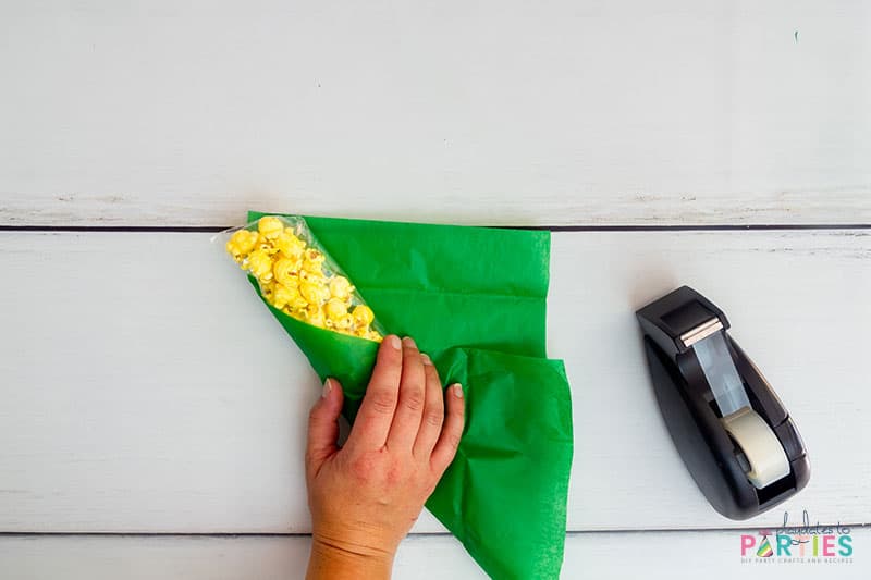 Wrapping the tissue paper around the popcorn bag.