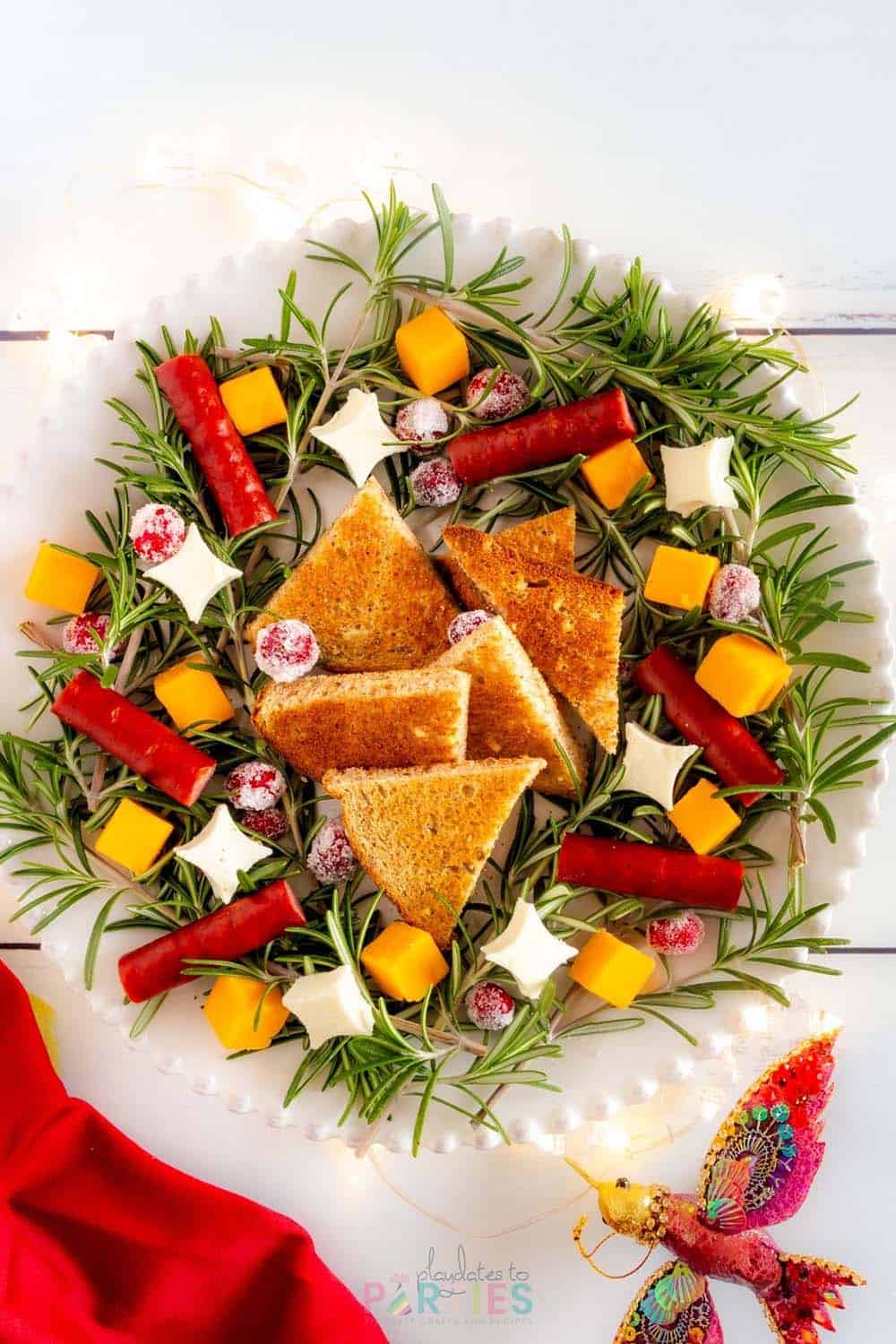 A Christmas appetizer wreath on a white dinner plate with toast in the center.