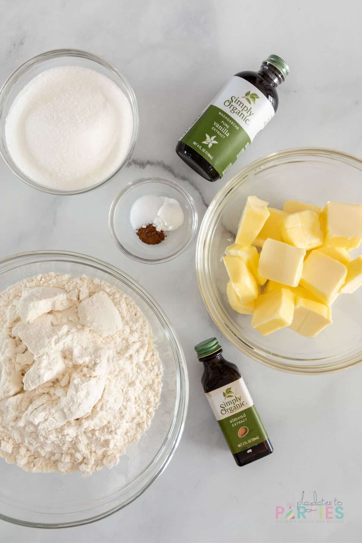Ingredients for cut out sugar cookie recipe on a marble surface.