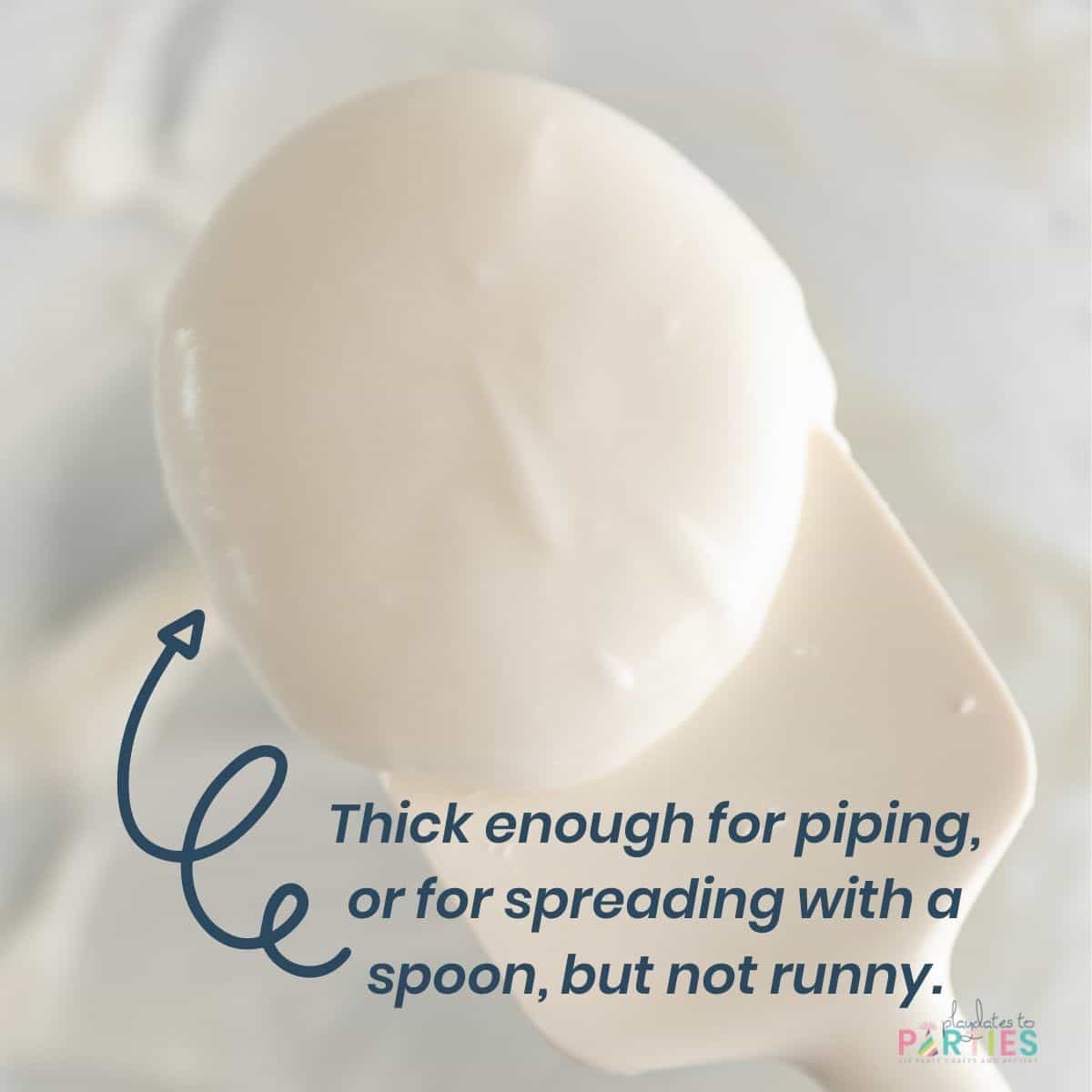 Close up of cookie icing on a spatula with text that says thick enough for piping, or for spreading with a spoon, but not runny.