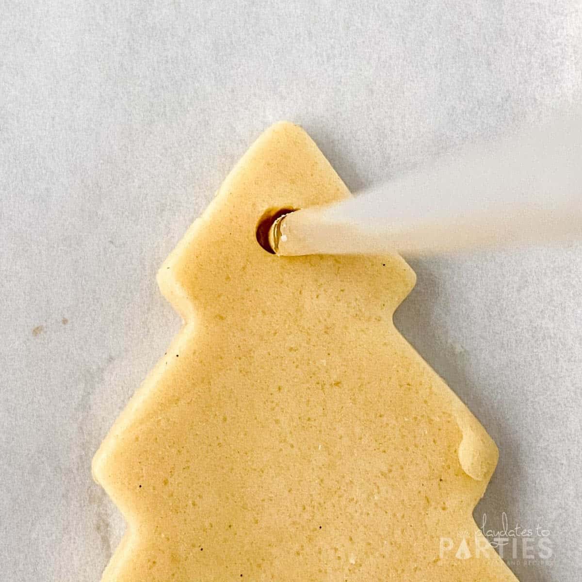 Making a hole in the cookie dough.