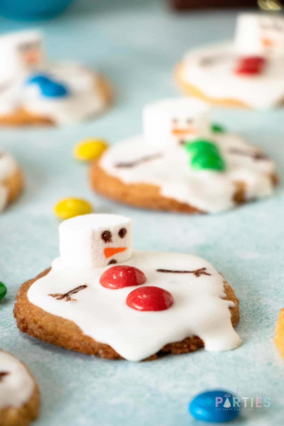 A sugar cookie decorated to look like a snowman that is melting.