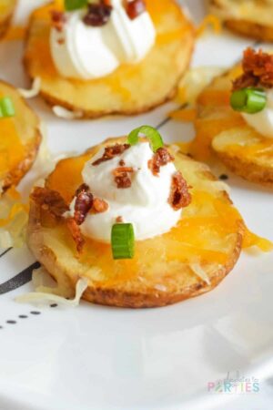 Close up of loaded baked potato bites with cheese, sour cream, and bacon.