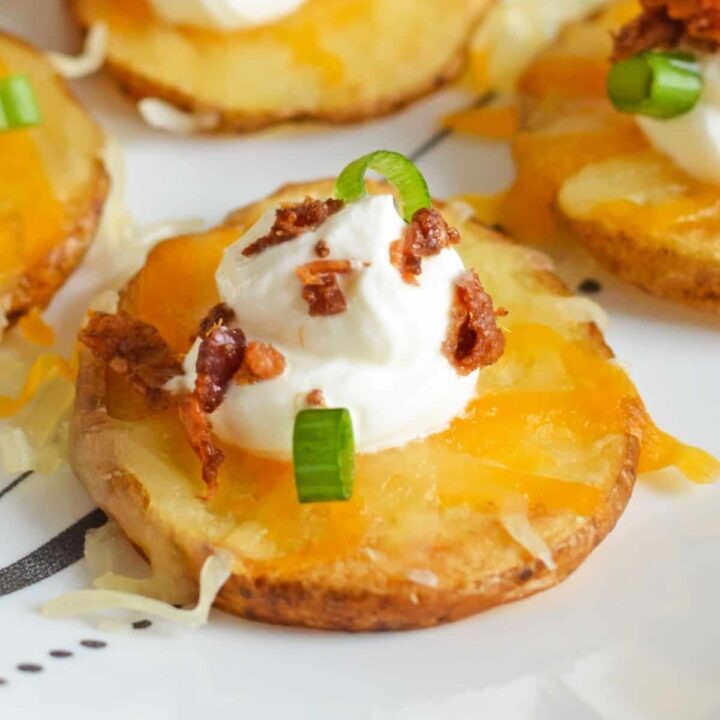 Close up of loaded baked potato bites with cheese, sour cream, and bacon.