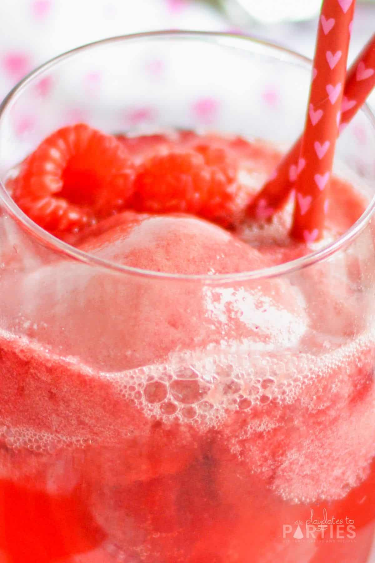 Close up of a bubbly champagne cocktail with sorbet and fresh fruit.